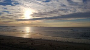 Ein Strand mit breitem Sandufer und ruhigem Wasser.