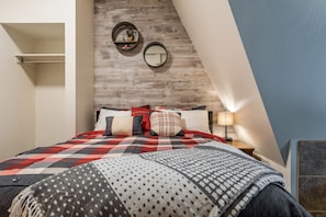 Relax in this inviting bedroom with a large bed, rustic headboard, and cozy atmosphere.
