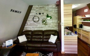 Cozy family living area with a sofa, kitchenette, and comfortable seating for relaxation.
