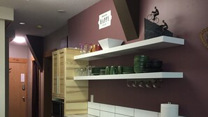Een keuken met houten kastjes, een marmeren aanrecht en een bordje aan de muur.