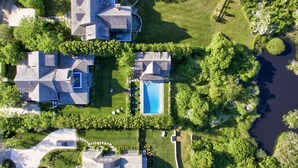 An aerial view of a residential area with two houses, a swimming pool, and a river. - 5 star, grand 8 BR estate, large yard, pool, pond, walk to town & beach (Nantucket)