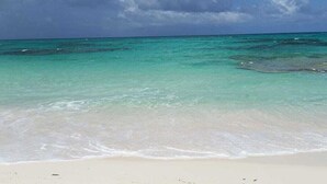 A beach with clear turquoise water and a sandy shore.