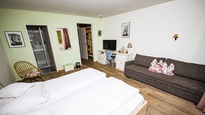A bedroom with a large bed, a sofa, a desk with a computer, and a chair. - Beautiful Family Apartment (Hinterbichl)