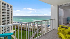 A balcony with a view of the beach and ocean.