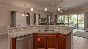 A modern kitchen with granite countertops, wooden cabinets, and a stainless steel dishwasher.