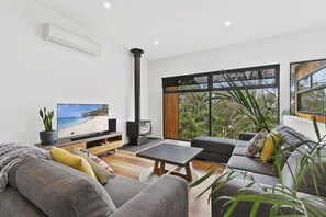A modern living room with a television, sofa, and a fireplace. - Lorne Hiatus (Lorne)