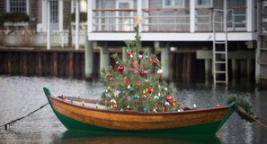 Un bateau décoré d’un sapin de Noël orné de différents objets.