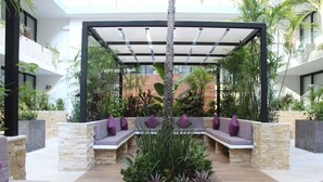 Een overdekt terras met stenen muren en beplanting.