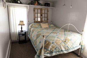 A bedroom with a bed, a nightstand, a lamp, a window with curtains, and a wall clock. - Country Farmhouse, family friendly, beautiful views, gorgeous sunsets (Thomas)