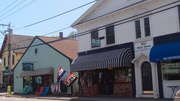 A street view with buildings, including a shop with a striped awning and a sign that reads "360 Main Street."