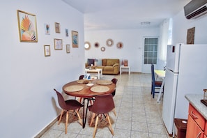 Um espaço compacto com área de refeições, cozinha e sofá.