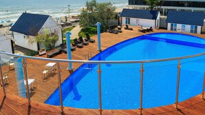 A pool with a view of the beach and ocean.