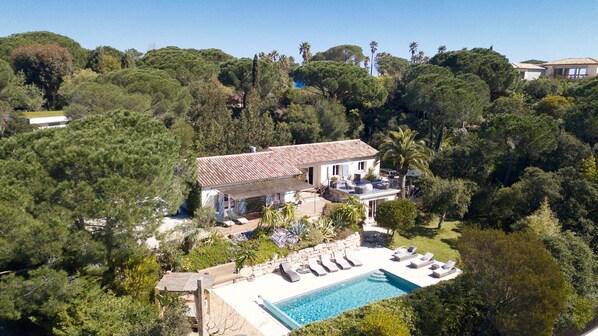 Une villa dotée d’une piscine, entourée d’une végétation luxuriante et située dans un paysage vallonné.