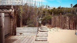 A wooden boardwalk leading to a beach area with a sign reading "CLUB 55". - Contemporary villa 500 m beach and club 55 (Ramatuelle)