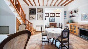 Uma sala de jantar com mesa, cadeiras e escada.