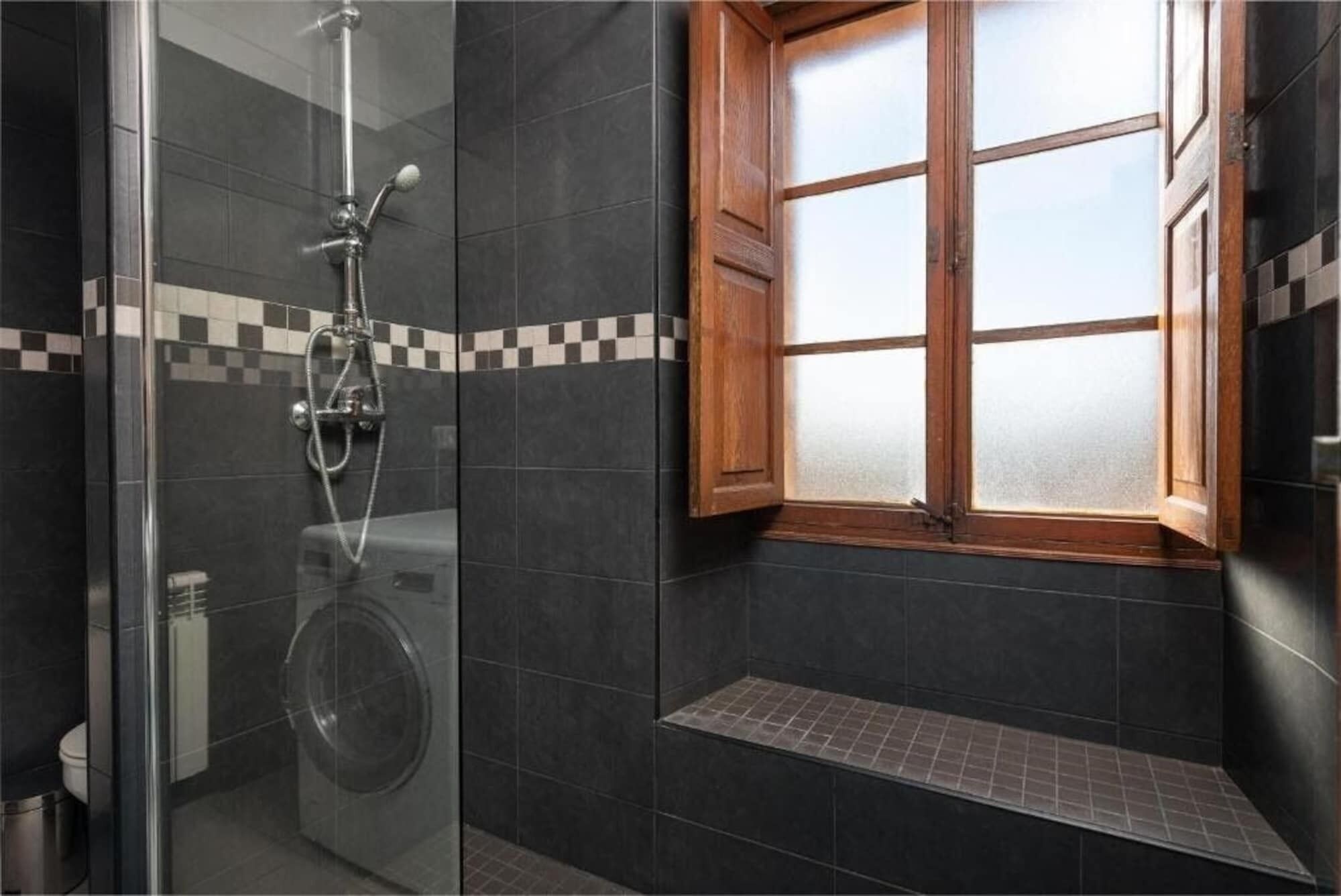 Een bad/douchecombinatie, een haardroger, handdoeken, toiletpapier