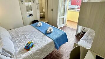 Ein Hotelzimmer mit Bett, Schreibtisch, Stuhl, Kleiderschrank, Badezimmer und Blick nach außen.