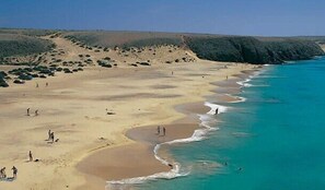 Une plage aux eaux turquoise et limpides, bordée de sable fin.