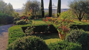 A well-maintained garden with neatly trimmed hedges, a variety of flowering plants, and tall cypress trees. - Luxury Villa in Montepulciano - Private Heated Pool, Free WiFi, Magnificent view (Montepulciano)