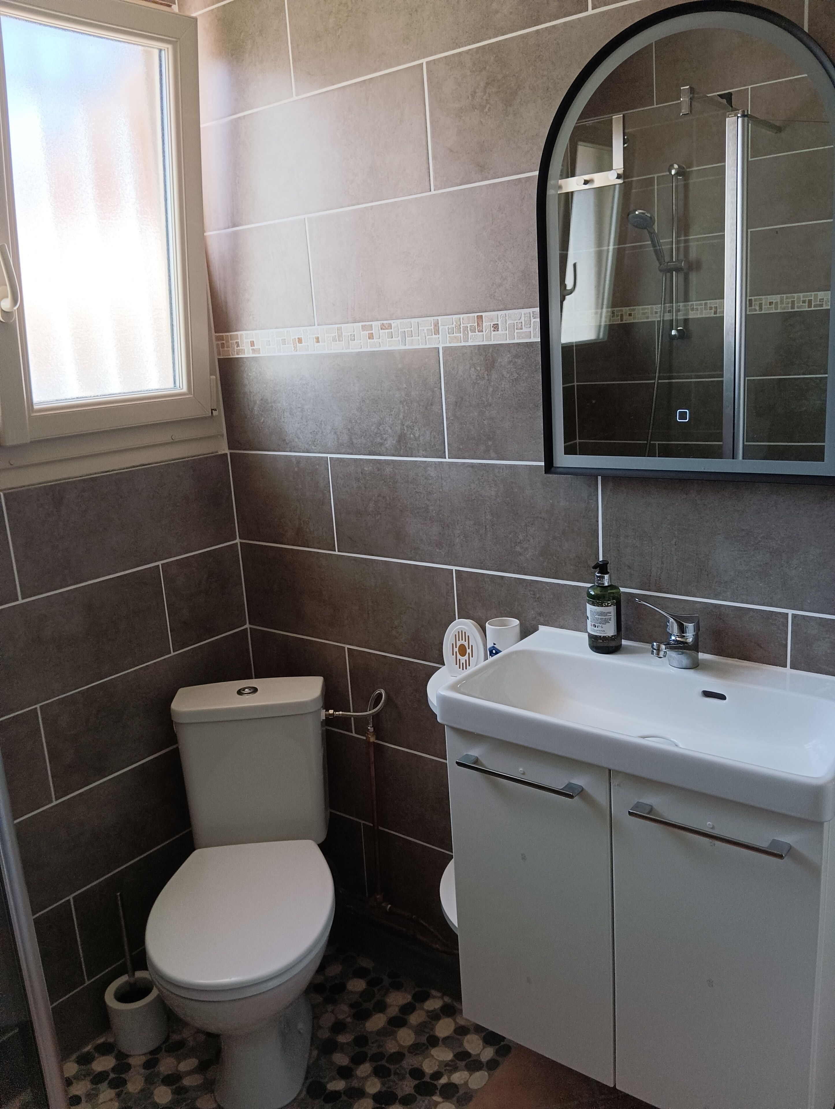 A bathroom with a toilet, sink, and shower.