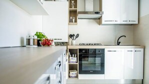 A modern kitchen with stainless steel appliances, a built-in oven, and a dishwasher. - bright apartment fully restored (murano)