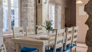 Un coin repas avec un mur en pierre, une table en bois et des chaises.