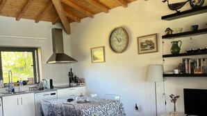 Una cuina moderna amb taula de menjador, sofà i televisió.