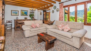 Ein Wohnzimmer mit zwei Sofas, einem Holztisch und einem Essbereich mit Tisch und Stühlen.