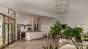 A spacious living area with a kitchen, large windows, and a chandelier. - House / Villa - MarrakechHouse with garden (Marrakesh)