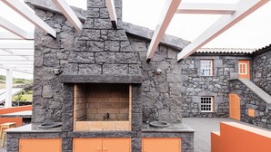 Een open haard van natuursteen met oranje kasten en een stenen muur.