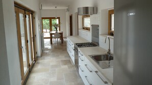A modern kitchen with a gas stove, stainless steel sink, and a Bosch refrigerator. - Architecturally Designed Sea View Villa in Carovigno, Nr Ostuni with Heated Pool (carovigno)