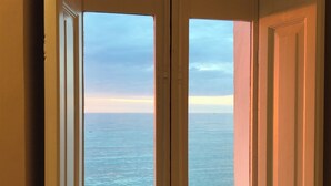A view through a doorway to the ocean, with a clear sky and calm sea. - Large apartment for exclusive use on the sea (Trapani)