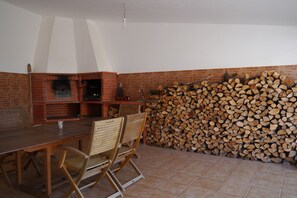 Cozy dining area with a brick fireplace and wooden table.
