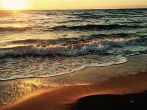 Une plage avec des vagues au coucher du soleil.