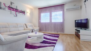 A modern living room with a sofa set, a coffee table, a TV, and a striped rug. - Luxury Villa With Pool, Gym, Bicycles And Beautiful Sea View (Kaštel Sucurac)