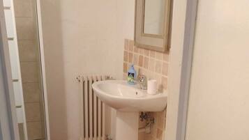 Ein Badezimmer mit Waschbecken, Toilette und Duschbereich.