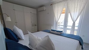 Een slaapkamer met een bed, een kledingkast en een raam met gordijnen.