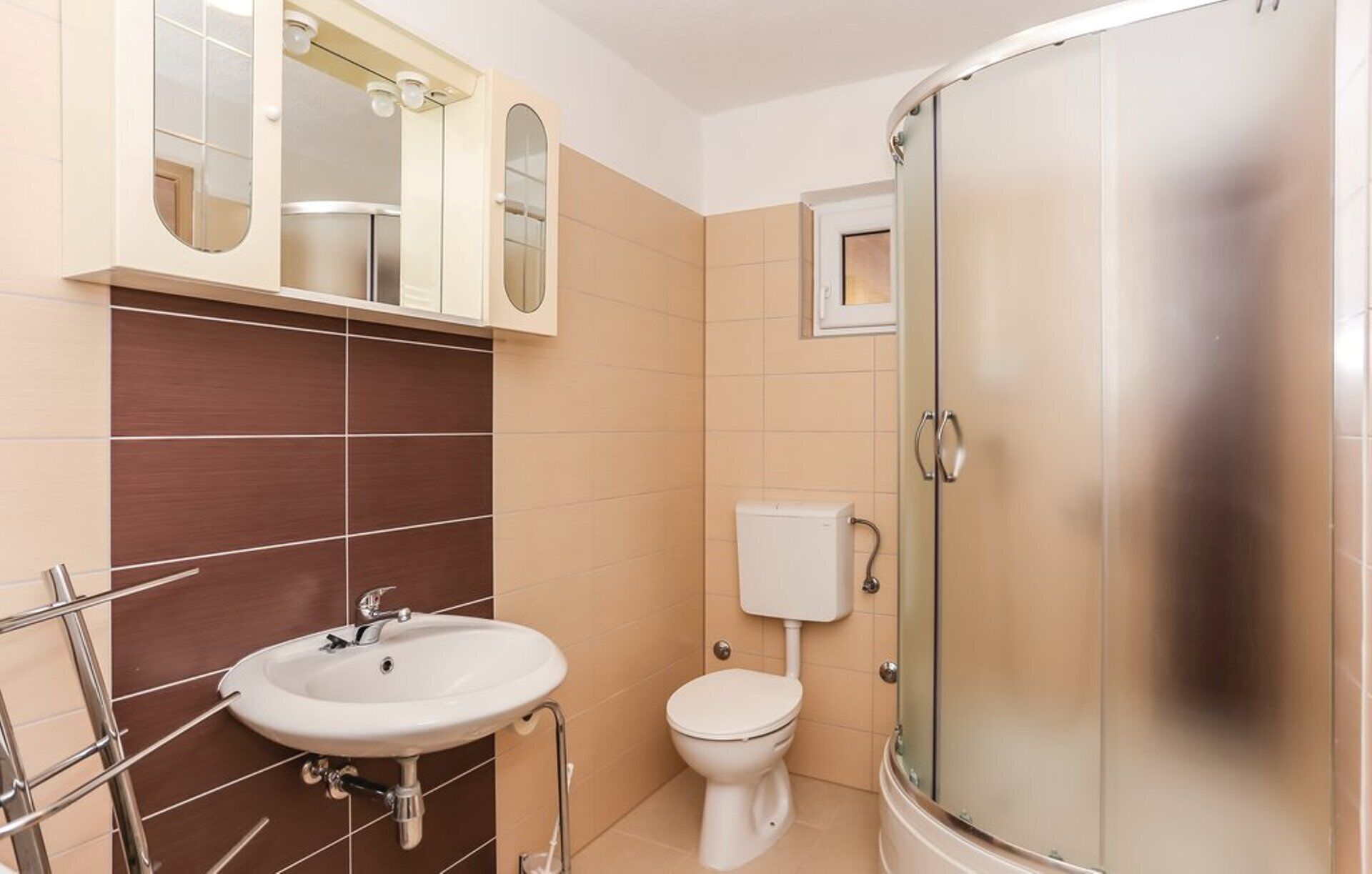 A bathroom with a sink, toilet, and shower.
