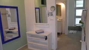 A bathroom with a white vanity, a mirror, and a towel rack. - Modern 3 bedroom garden apartment with maximum privacy (Castino bei Alba)