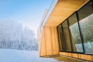A modern building with large windows and a wooden exterior. - Aurora Villa (Fairbanks)