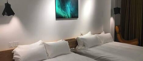 A hotel room with two beds, a painting on the wall, and a chair.