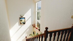 A staircase with a wooden railing, a potted plant, and a framed picture on the wall. - Gorgeous apartment in Okrug Gornji (Okrug Gornji)