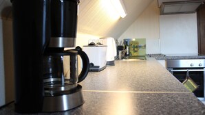 A kitchen with a coffee maker, toaster, and oven. - Very nice apartment with a large sun terrace (Stadtkyll)