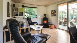 A cozy living room with a fireplace, leather chairs, a coffee table, and a bookshelf. - 3 bedroom stunning home in Hjerm (Hjerm)