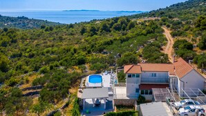 Eine Villa mit Pool, Meerblick und einer Berglandschaft.