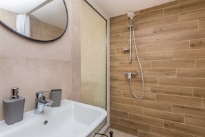 Regadera, secadora de cabello, toallas, papel de baño