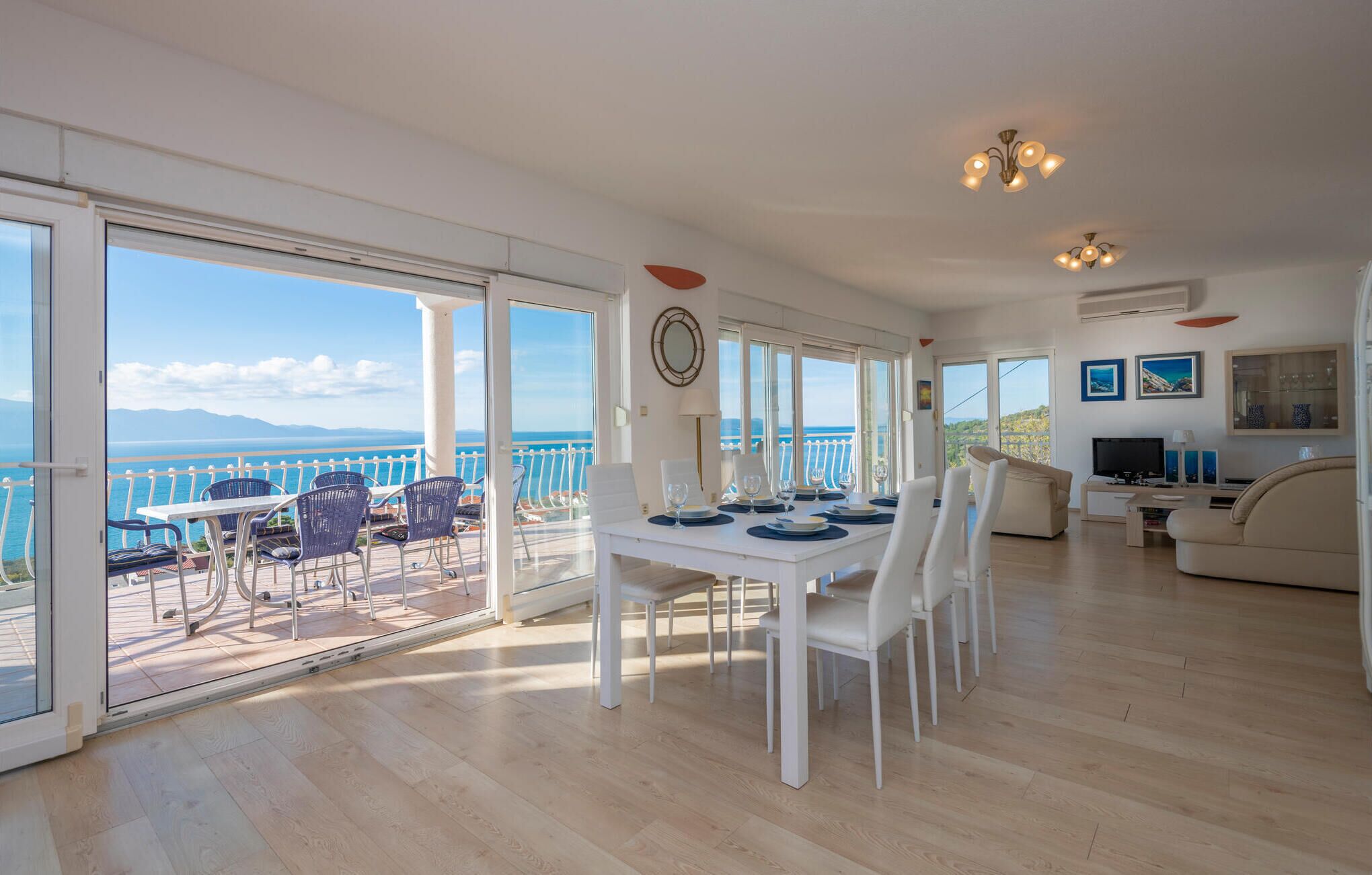 A spacious living area with a balcony overlooking a scenic ocean view.