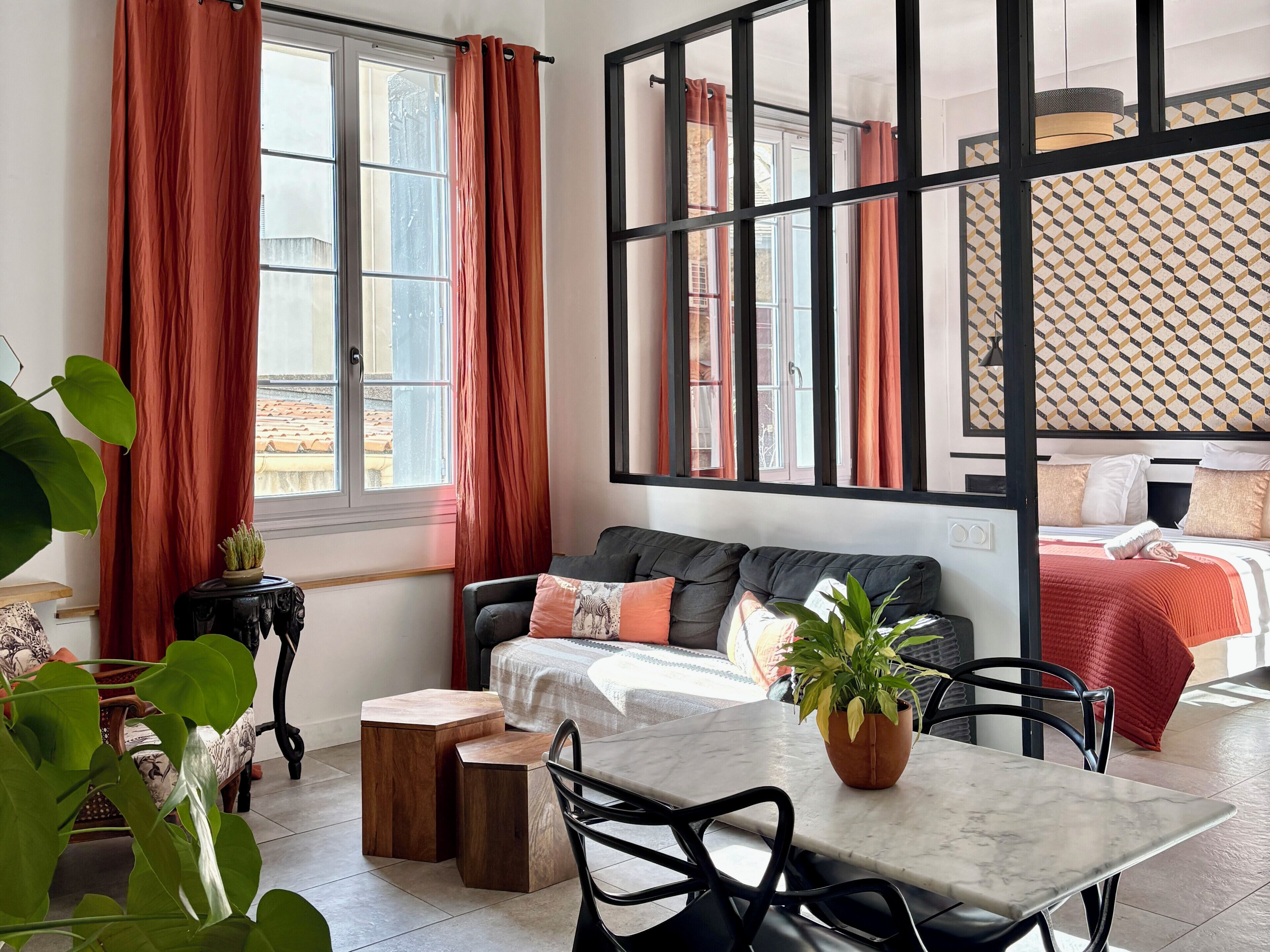 A modern room with a sofa, a dining table, and a bed.