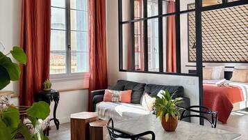 A modern room with a sofa, a dining table, and a bed.