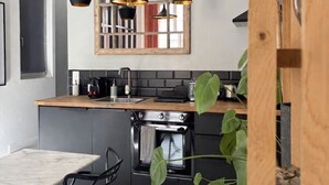 A kitchen with a wooden countertop, a built-in oven, and pendant lights. - Home Chic Home - Les Suites de La Comédie - Suite2 (Montpellier)